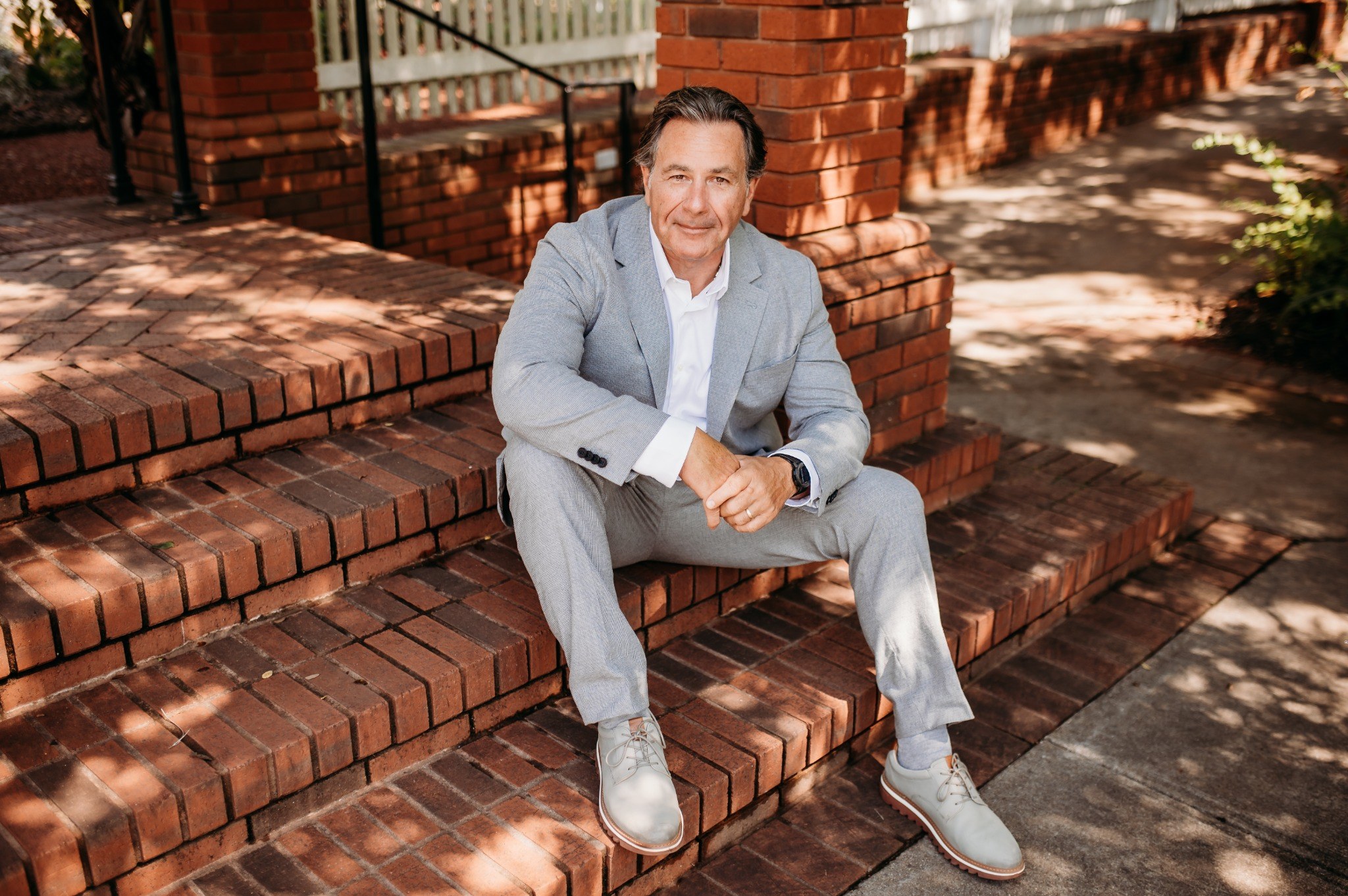 John Pieper seated on brick steps outdoors